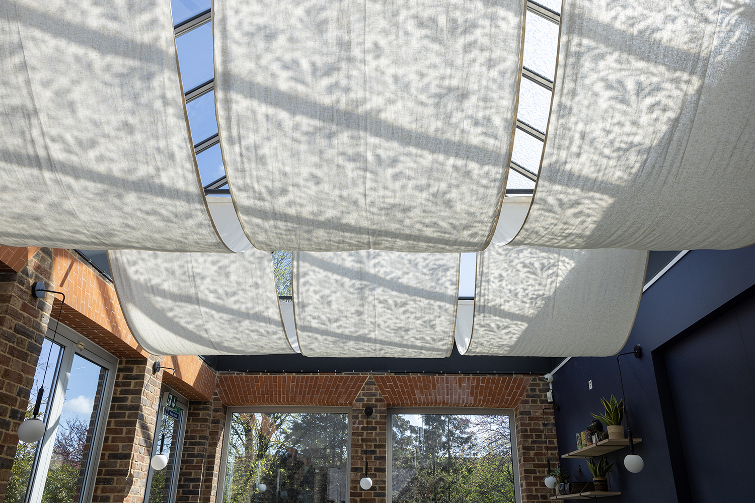 Image of the roof of William Morris Gallery's Cafe. Sun is shining through the roof into the Cafe below.