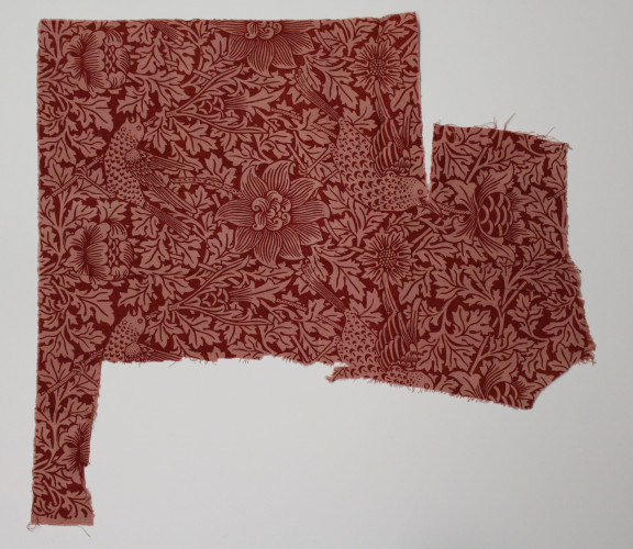 Sample of fabric featuring a floral design in red with rows of birds.