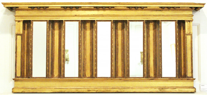 An ornate gold mirror with five reflective panes, each flanked by two narrow angled panes