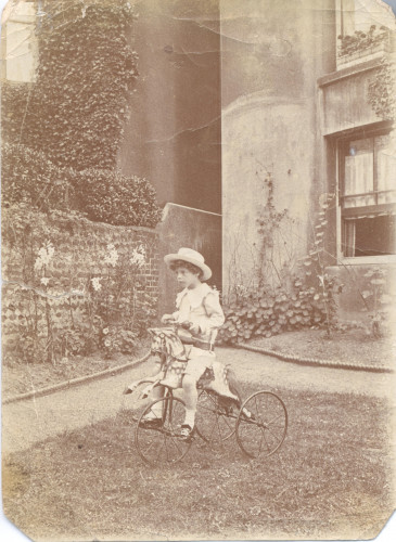 A child sits on a tricycle styled after a rocking horse