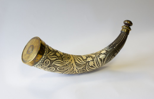 Light yellow brown horn, engraved with leaves and flowers. Mouth of horn fitted with brass rim and engraved 'WM' in the centre, 'stopper' made of turned wood.