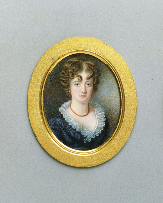 An oval shaped portrait of a young woman in a gold frame