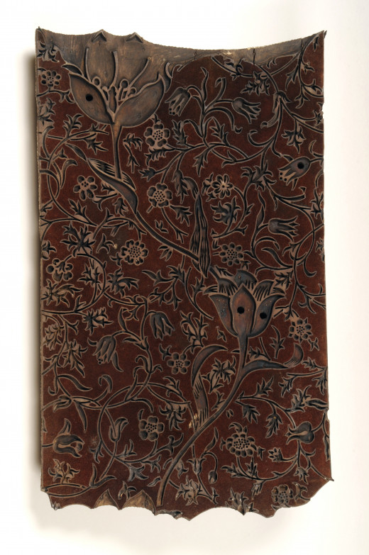A carved wooden printing block with a detailed floral pattern